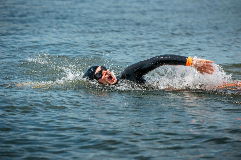 Image of a man swimming wearing a wetsuit