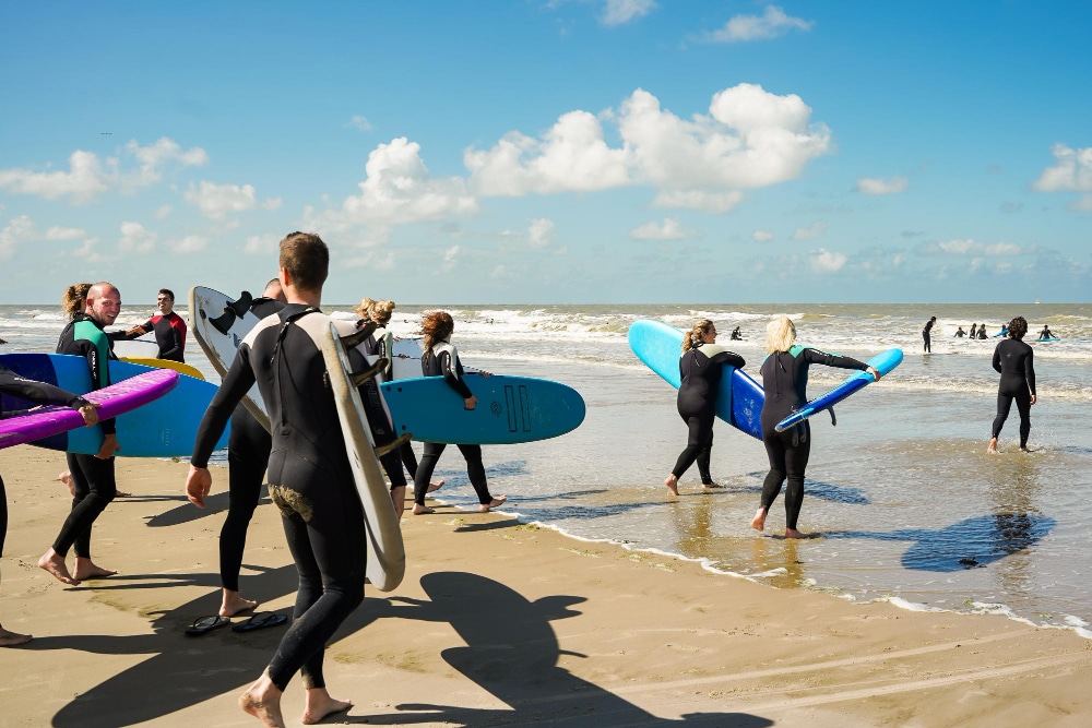 Image of people in beach preparing to surf